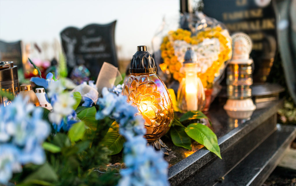 Jak wybierać znicze na grób - zapalone znicze na cmentarzu